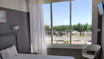 Habitación doble estándar, vista parcial al mar | Escritorio, tabla de planchar con plancha, wifi gratis y ropa de cama