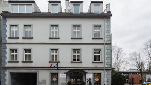 A multi-story building with a central entrance, multiple windows, and a flag. - Antica Residence (Kraków)