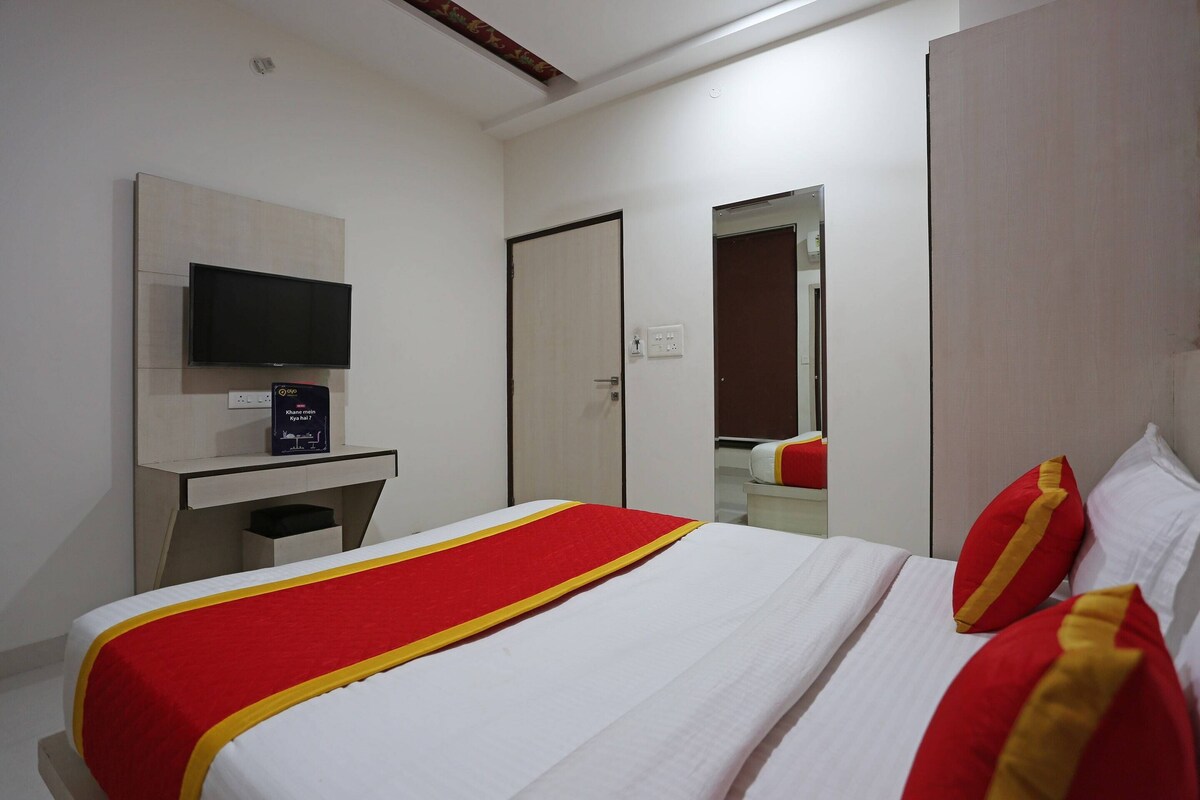 A hotel room with a bed, a TV, a desk, and a wardrobe.