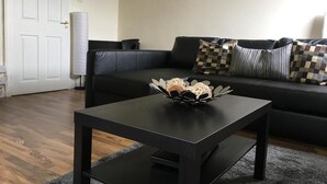 A living room with a black sofa, a black coffee table, and a decorative bowl on the table. - Majesty Tweed Apartment (Dundee)