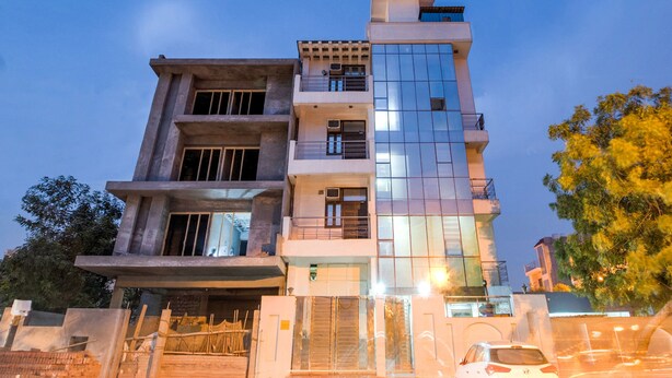 A multi-story building with a modern architectural design, featuring a mix of concrete and glass elements. - OYO 2807 Hotel Crosswinds Residency (Noida)