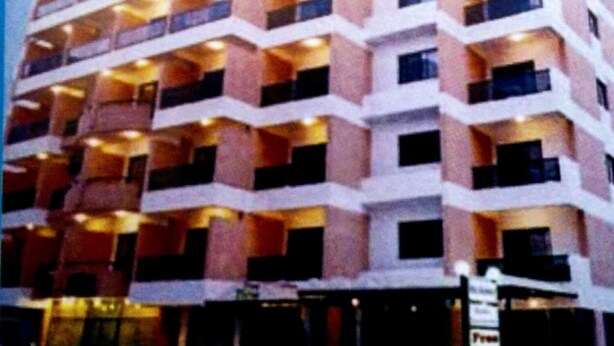 Un hotel de varios pisos con una fachada en zigzag, balcones en cada planta y ventanas iluminadas.