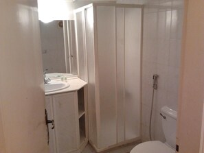A small, compact bathroom with a sink, mirror, and toilet. - Real Lux Apartments (Zouk Mosbeh)