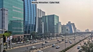 A modern urban street with high-rise buildings, a busy road, and a Cyber Hub sign. - OYO 6590 Hotel Amaraa (Gurugram)