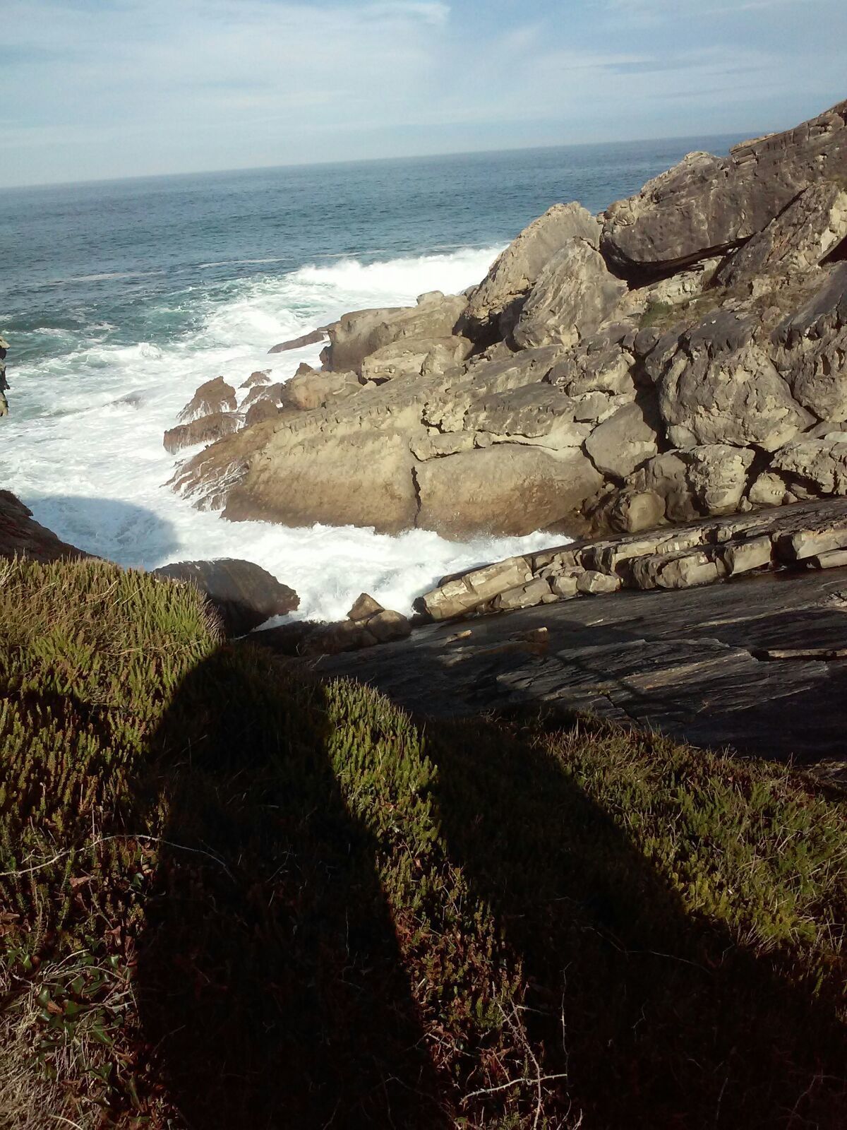 A rocky coastline with waves crashing against the rocks.