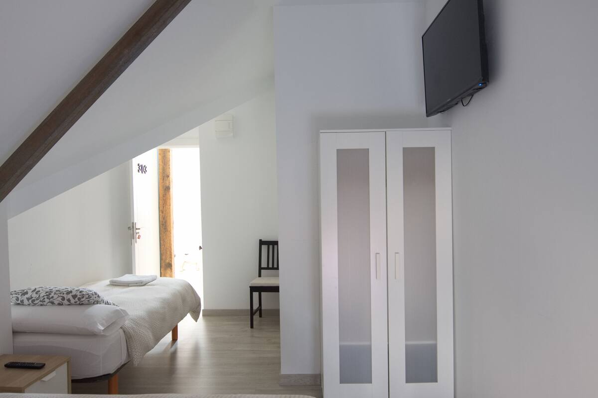 Une chambre à coucher avec un lit, une chaise et une armoire.