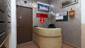 Un comptoir d’accueil avec une horloge, un tableau et un panneau d’affichage.