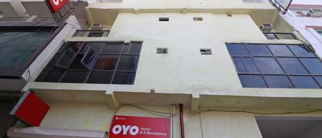 Un edificio de hotel con un letrero rojo que indica que es un Hotel OYO R S Residency.