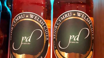 Two bottles of 'Cymharol Sych' medium dry cider with 'Cymru Welsh' branding, each labeled as 500ml.