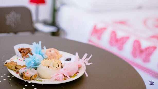 A plate of pastries on a table with a red lamp in the background. - Bed & Breakfast Il Carignano (Cagliari)