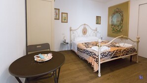 A bedroom with a bed, a table with a cake, and a chair. - Bed & Breakfast Il Carignano (Cagliari)