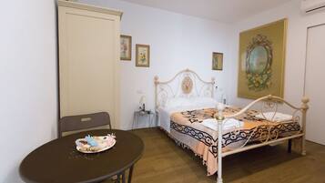 A bedroom with a bed, a table with a cake, and a chair.