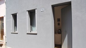 A gray building with two windows and a door. - Bed & Breakfast Il Carignano (Cagliari)