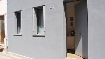 A gray building with two windows and a door.