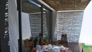 A dining area with a round table set for a meal, surrounded by chairs, and a glass partition. - Bed & Breakfast Il Carignano (Cagliari)