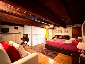 A cozy bedroom with a large bed, a sofa, a desk, and a TV. - Saint Patrick B&B Guesthouse (Barletta)