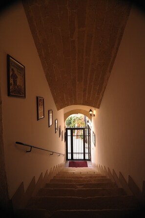 A staircase with stone steps and a metal handrail, leading to a black gate with a red mat at the bottom. - Saint Patrick B&B Guesthouse (Barletta)