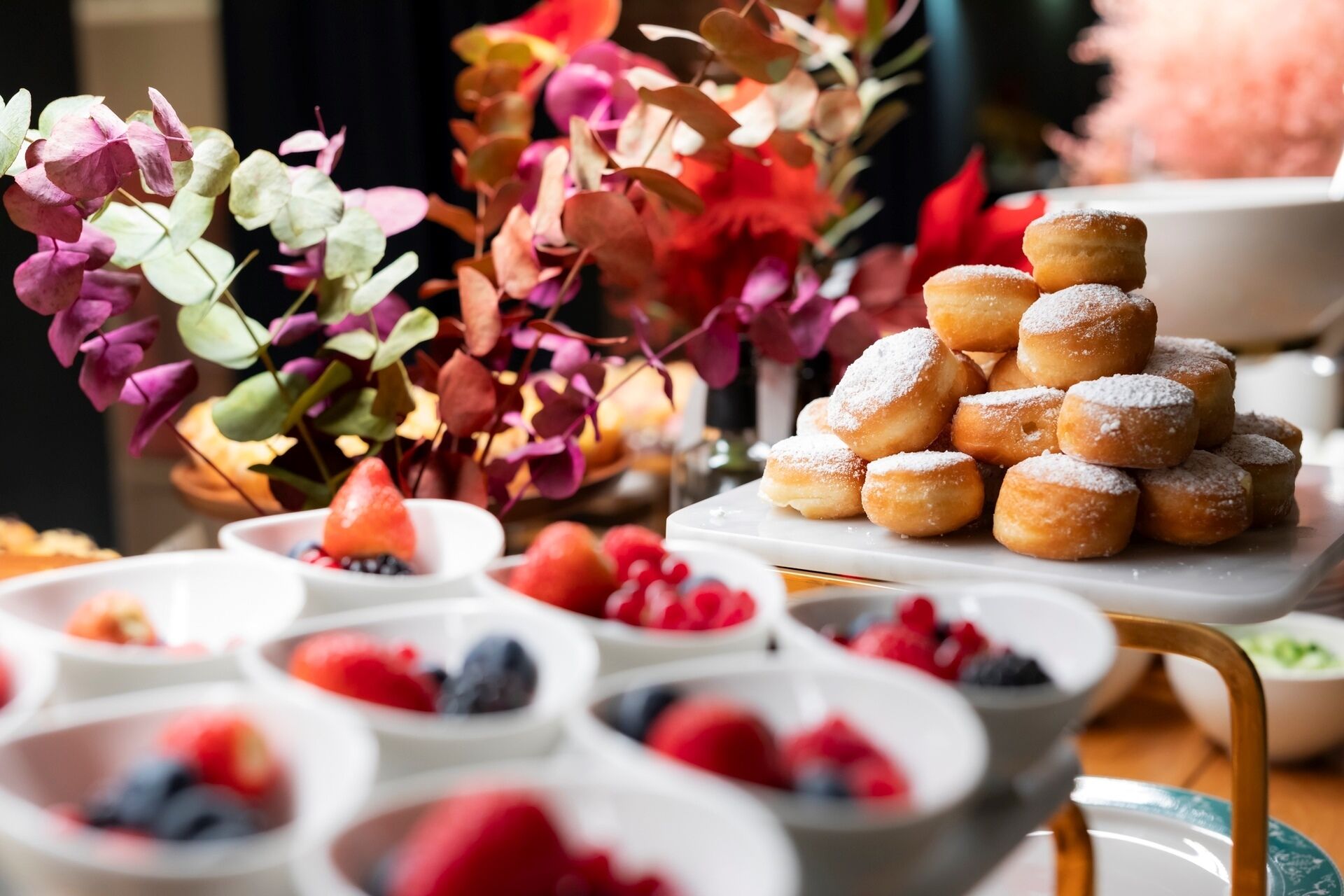 A buffet table with a variety of food items including pastries and fresh fruits.