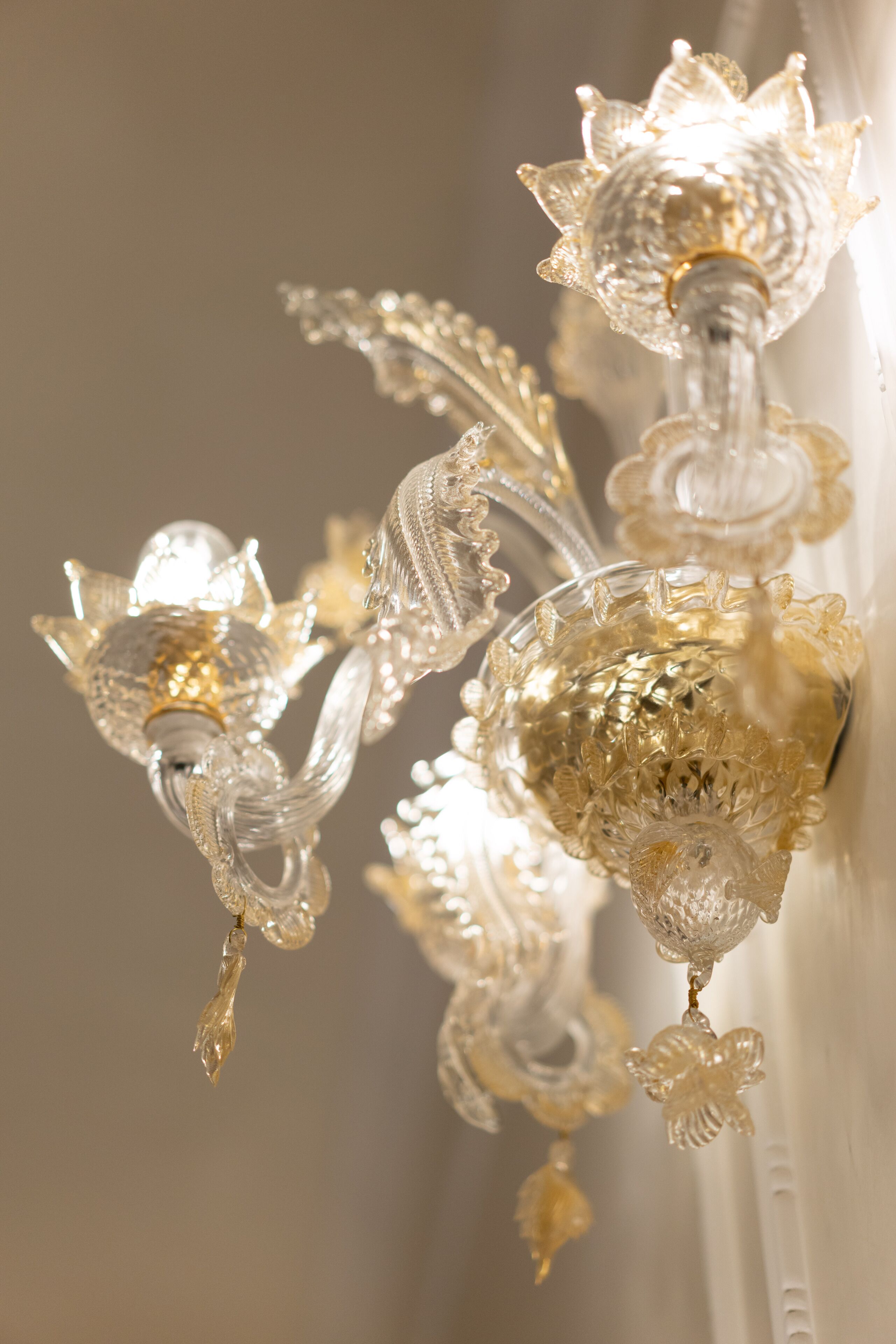 A close-up of a chandelier with intricate glass designs and multiple light sources.