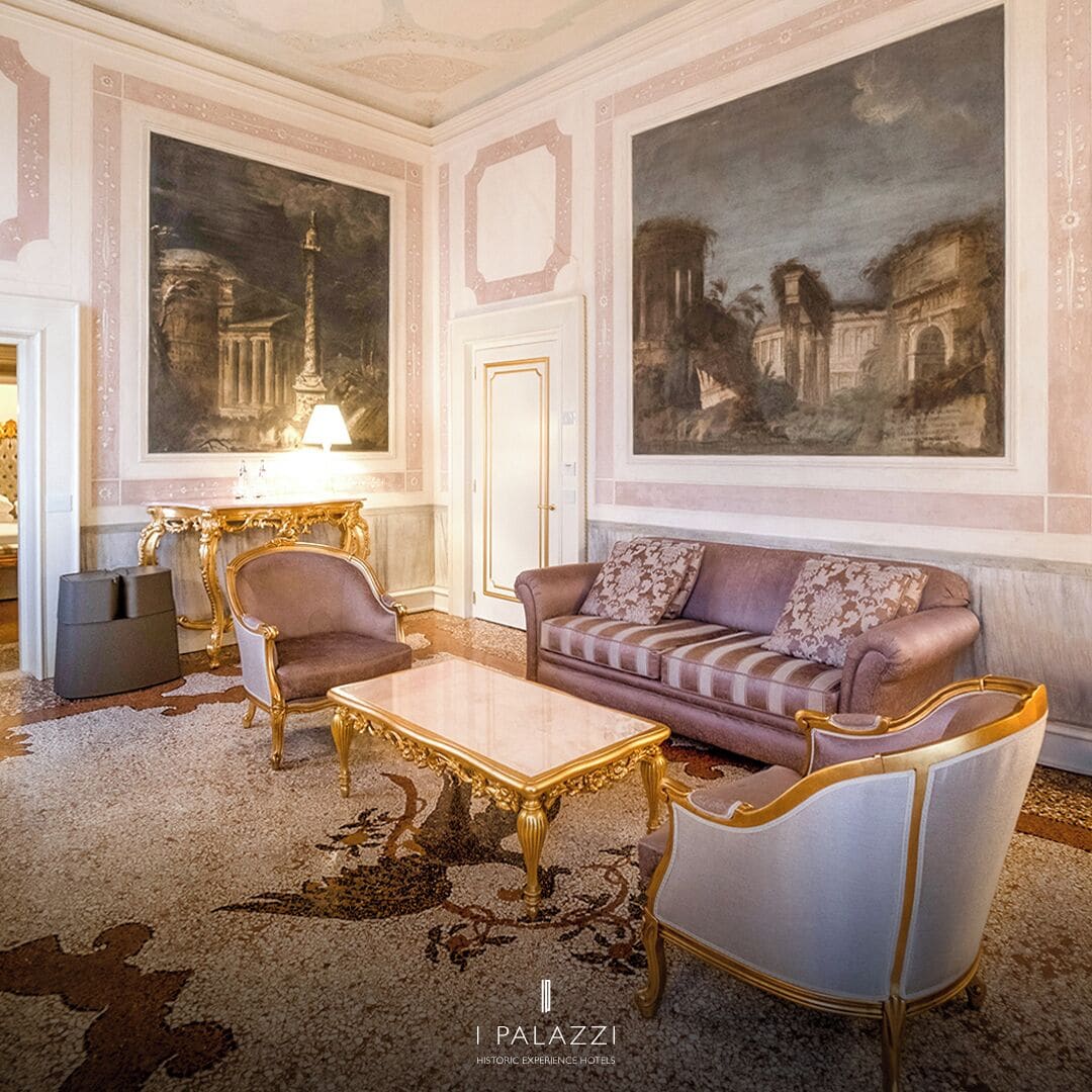 Eine luxuriöse Lobby mit einem Marmortisch, eleganten Sesseln, einer komfortablen Couch und großen, klassischen Gemälden an den Wänden.