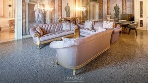 Un hall d’entrée luxueux, agrémenté d’un somptueux ensemble de canapés, de colonnes en marbre et de sculptures classiques.