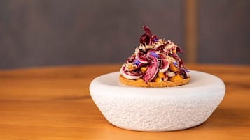 A dish on a white textured plate on a wooden table.