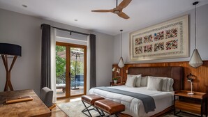Ein modernes Schlafzimmer mit einem großen Bett, einem Holzkopfende und Blick ins Freie.