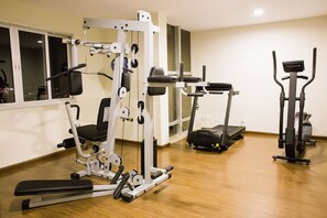 A gym with various exercise equipment including a weight machine, a treadmill, and a stationary bike. - TRYP by Wyndham Varginha Cafe Royal (Varginha)