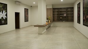 Eine geräumige Lobby mit einer Rezeption, gerahmten Kunstwerken an den Wänden und einer Produktvitrine.