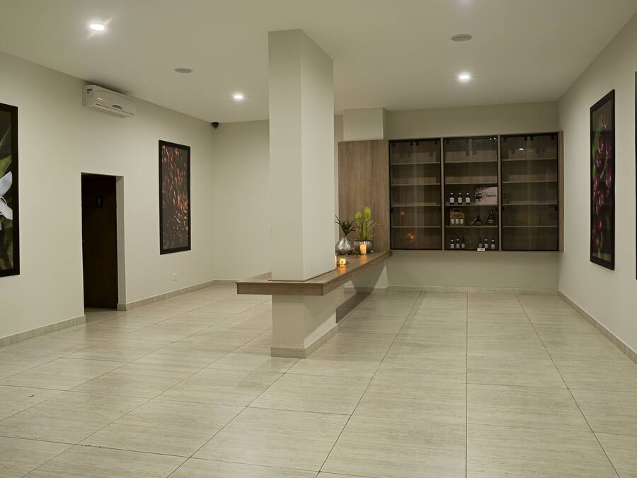 A spacious lobby with a reception desk, framed artwork on the walls, and a display cabinet with products.
