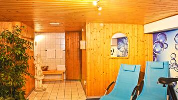 Relax in a serene sauna room with a bathtub, massage chairs, and a peaceful ambiance.