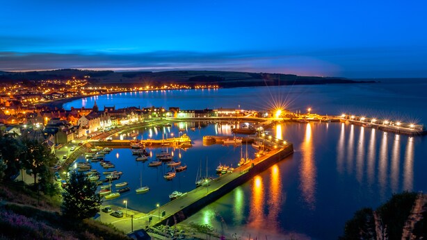 A coastal town at night with a marina, illuminated buildings, and a bridge. - Rooms at 31 (Stonehaven)