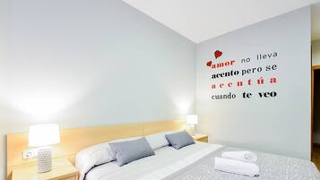 A hotel room with a bed, nightstands, and a wall with a motivational quote.