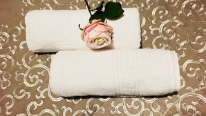 Two rolled towels on a patterned fabric background. - Hotel Viñas 17 (Teruel)