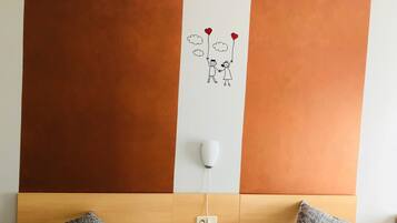 Un dormitorio con dos camas, cabeceros de madera, una mesita de noche y un adorno en la pared.