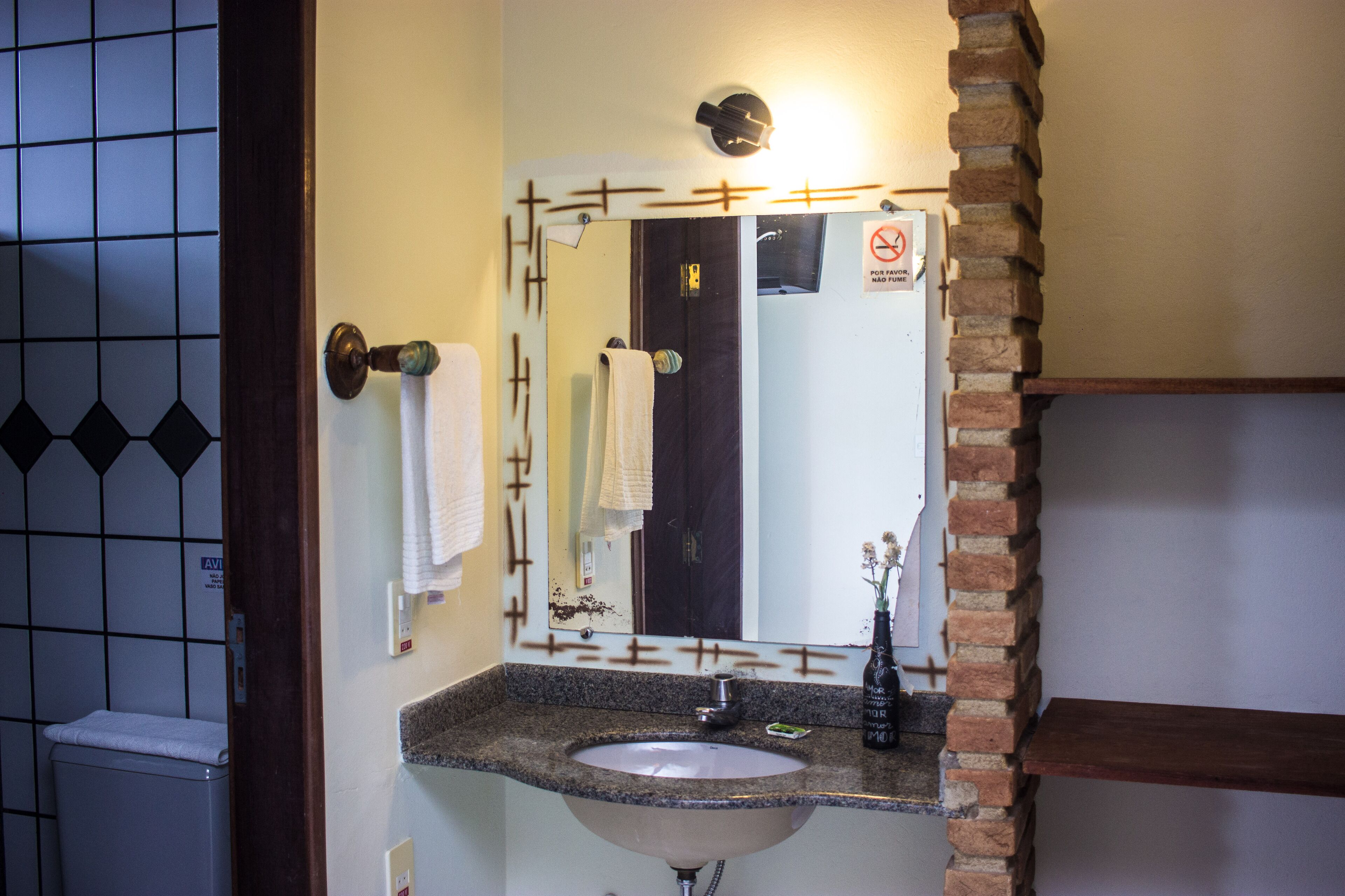 A bathroom with a sink, mirror, and towel rack.