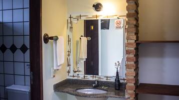 A bathroom with a sink, mirror, and towel rack.
