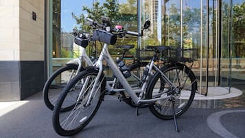 Una bicicleta estacionada frente a un edificio con entrada de vidrio.