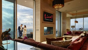 A modern living room with a glass coffee table, a sofa, and a fireplace. - Live! Casino & Hotel Maryland (Hanover)