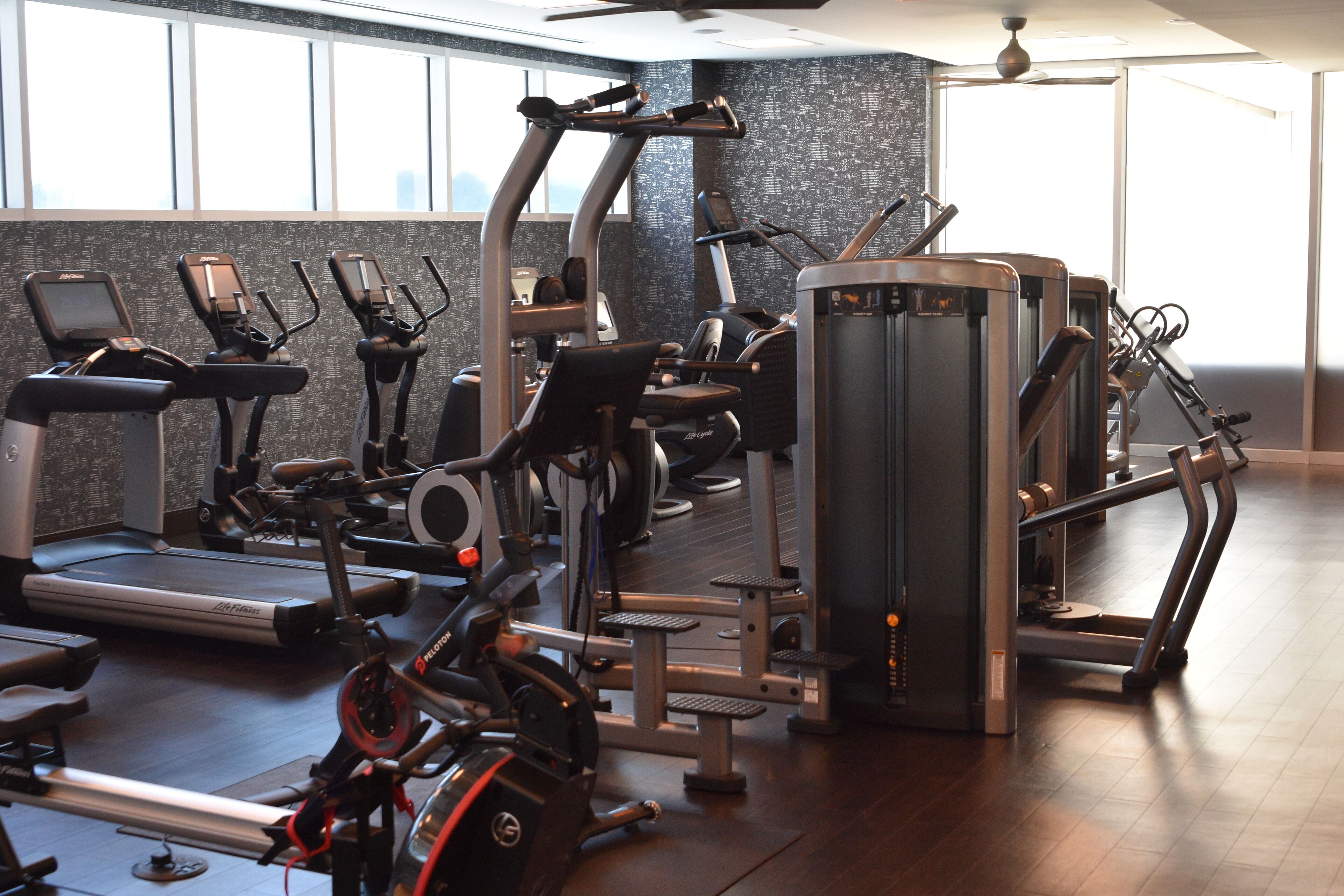 A gym with cardio machines, weight equipment, and a treadmill.