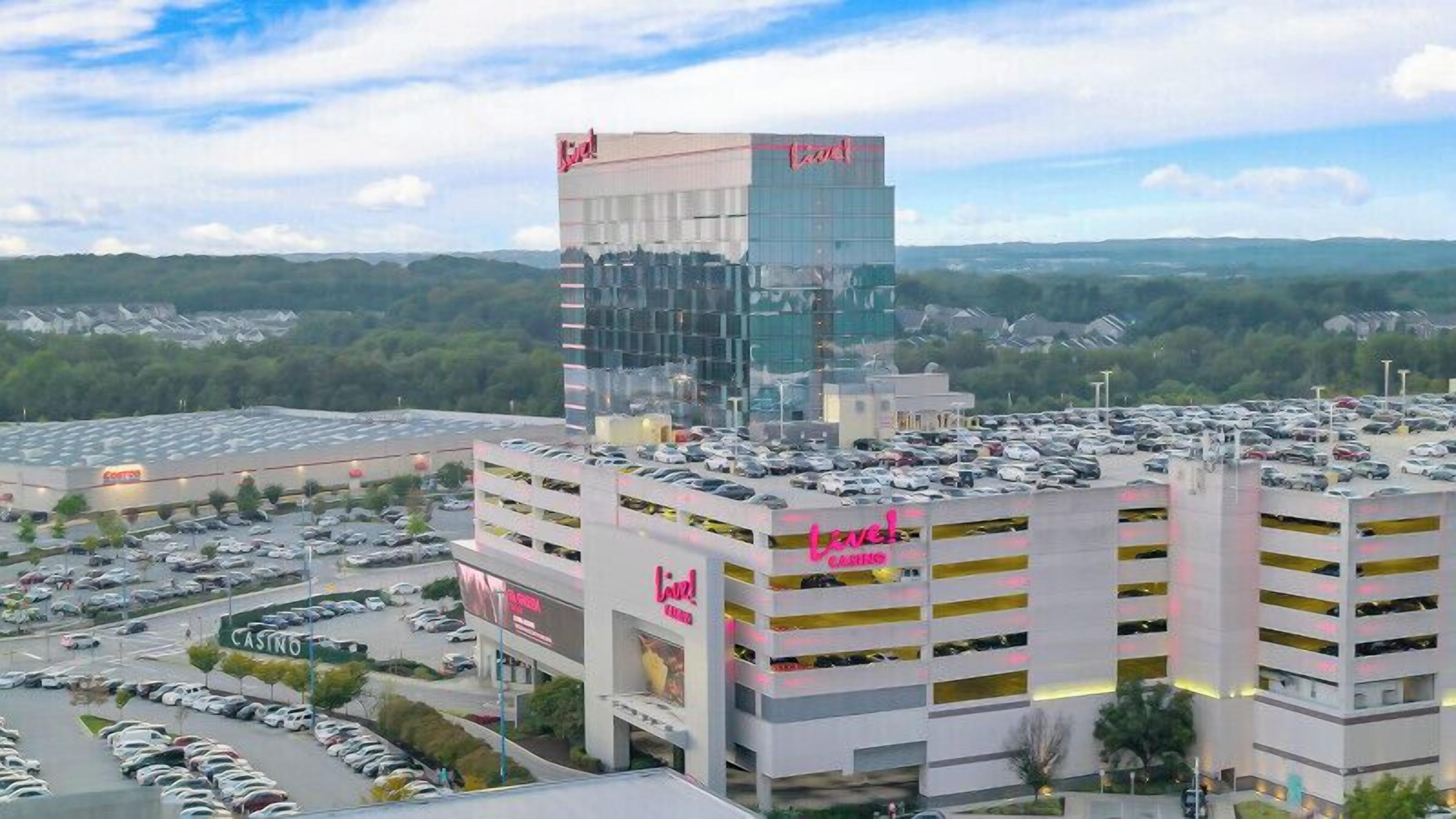 A multi-story hotel with a parking lot and a casino in the background.