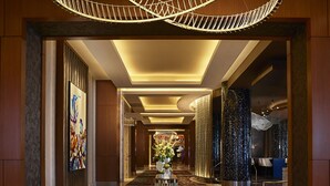 A spacious hotel lobby with a geometric patterned floor, a central reception desk, and a modern chandelier. - Live! Casino & Hotel Maryland (Hanover)