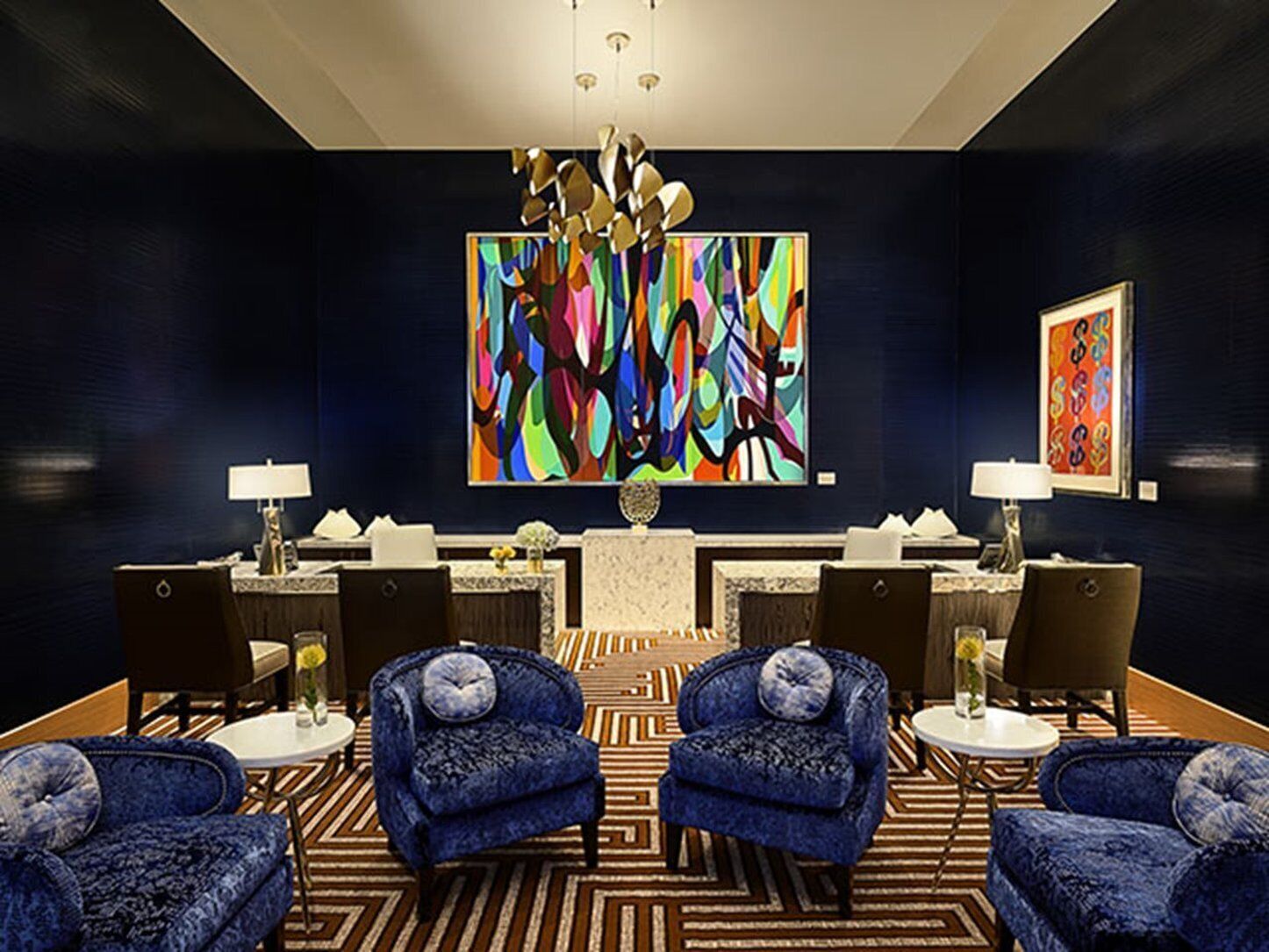 Un hall d’entrée moderne agrémenté d’un grand tableau abstrait, de deux canapés et d’un comptoir d’accueil.