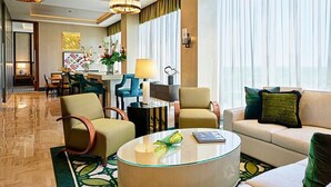 Un moderno vestíbulo de hotel con una zona de estar, un comedor y un gran ventanal con cortinas.