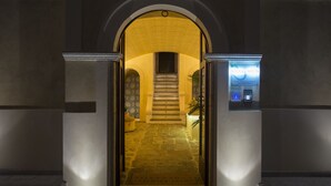A hotel entrance with a stone staircase leading to a second-floor landing. - Villa Adua (Tropea)