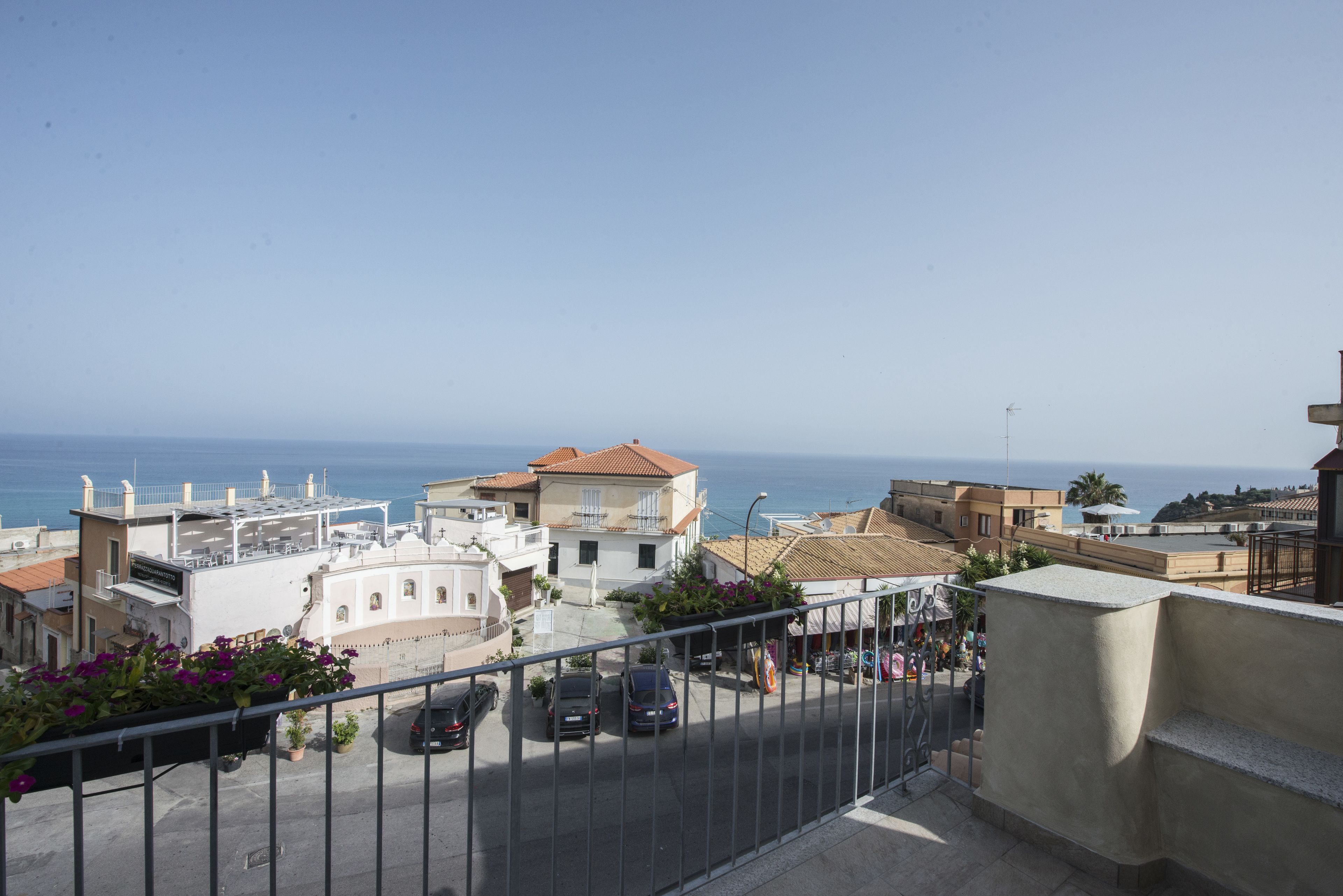 Una zona residenziale lungo la costa, con edifici, cielo sereno e il mare sullo sfondo.