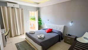 A modern bedroom with a bed, bedside table, and a chair. - Palace Hotel Costa Del Sole (Catania)