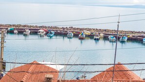 A harbor with multiple boats docked along a rocky shoreline. - Assos Yildiz Hotel (Ayvacik)