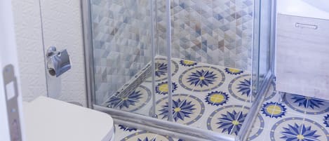 Baño con ducha, inodoro y pisos con diseño.