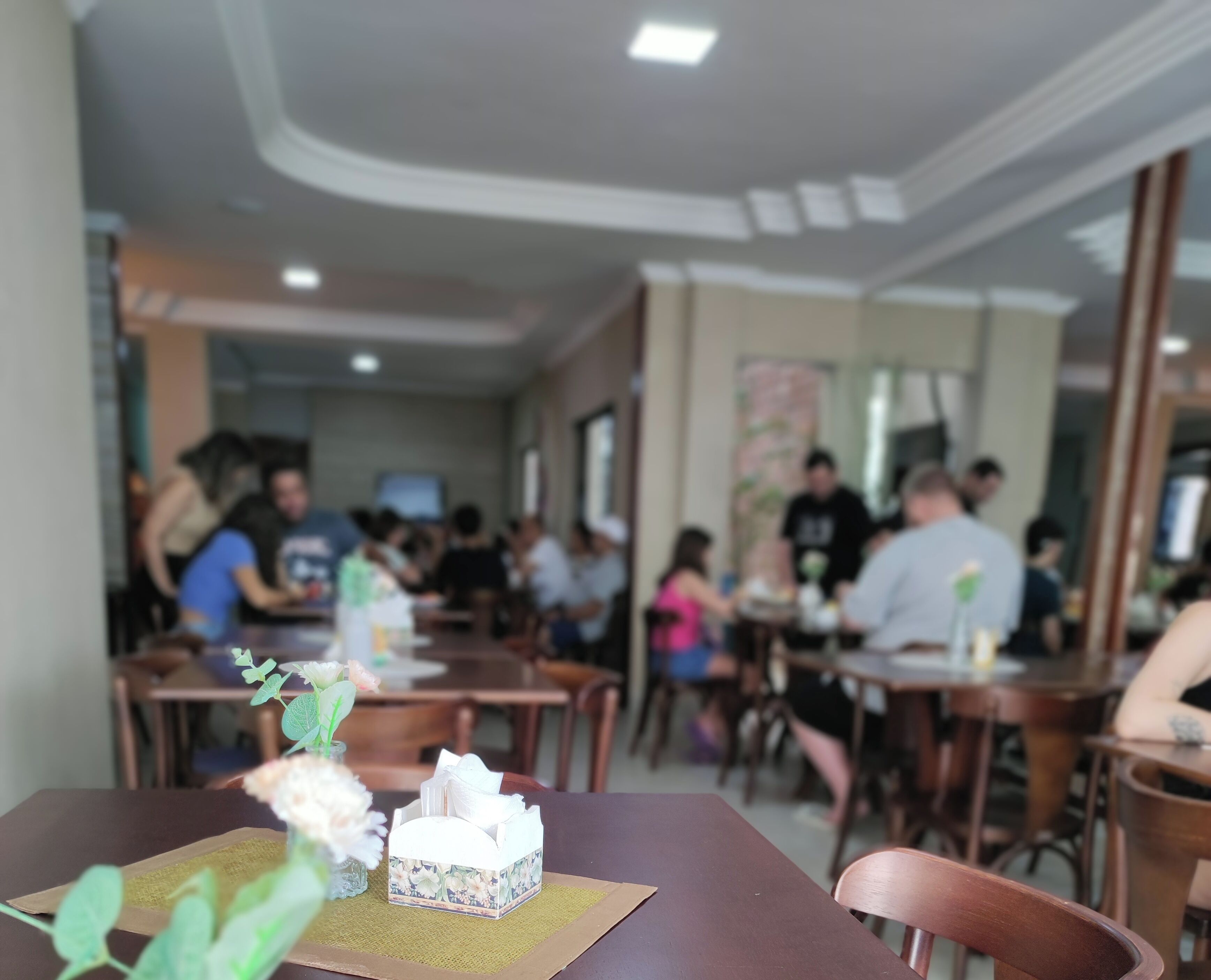 Interior de restaurante con mesas, sillas y zona de comedor.